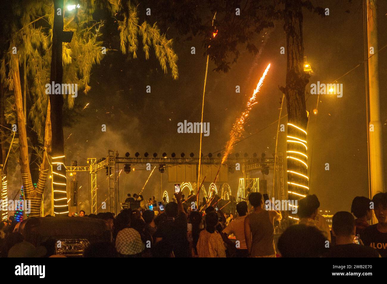 I fuochi d'artificio vengono girati da un concerto a mezzanotte sulla riva del fiume / Capodanno 2023 - 2024. Kampot, Cambogia. © Kraig Lieb Foto Stock