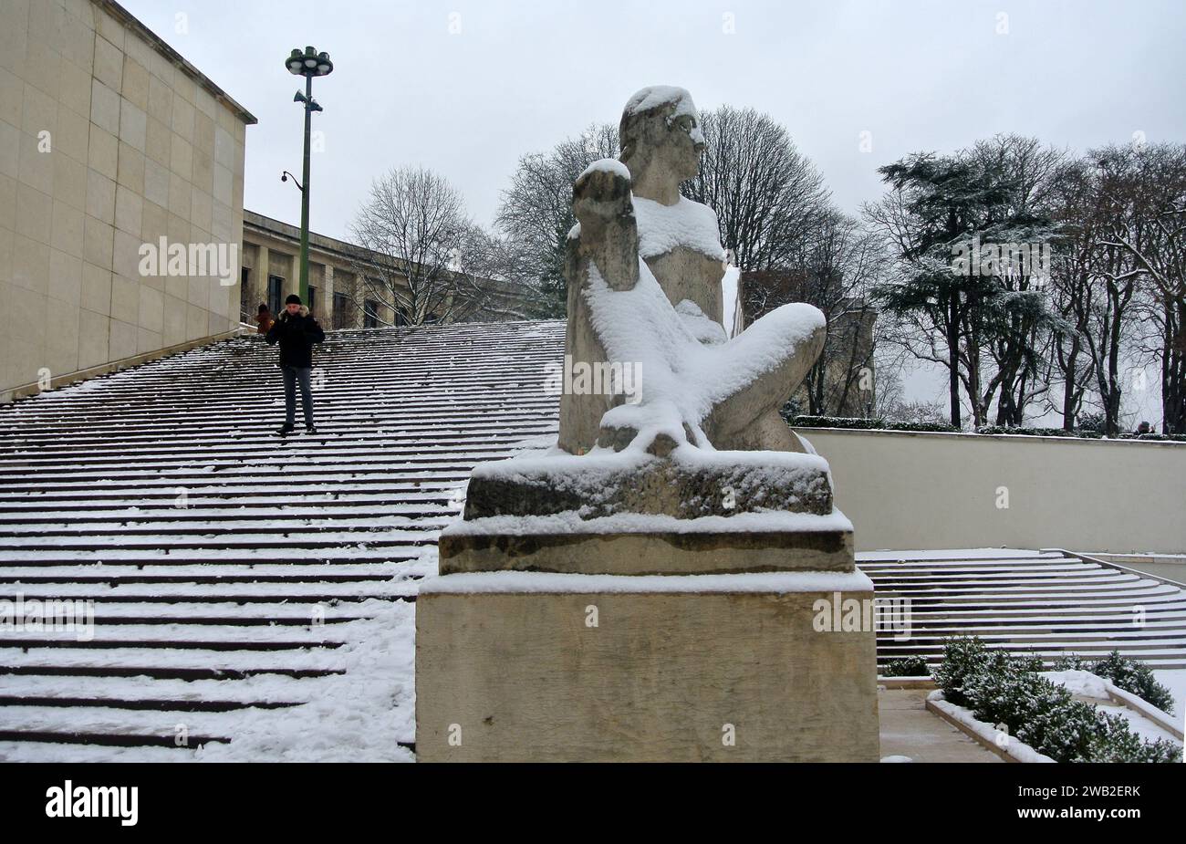 Neve inaspettata a Parigi. Giardino del Trocadero con sculture in pietra e Palazzo Chaillot ricoperto di neve. Foto Stock