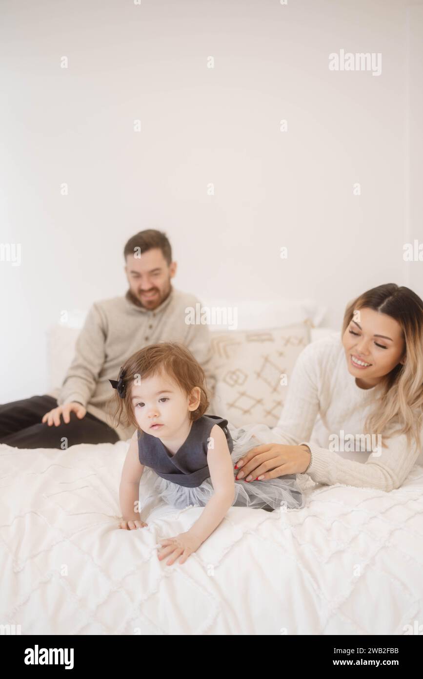Foto di famiglia seduto su un letto Foto Stock