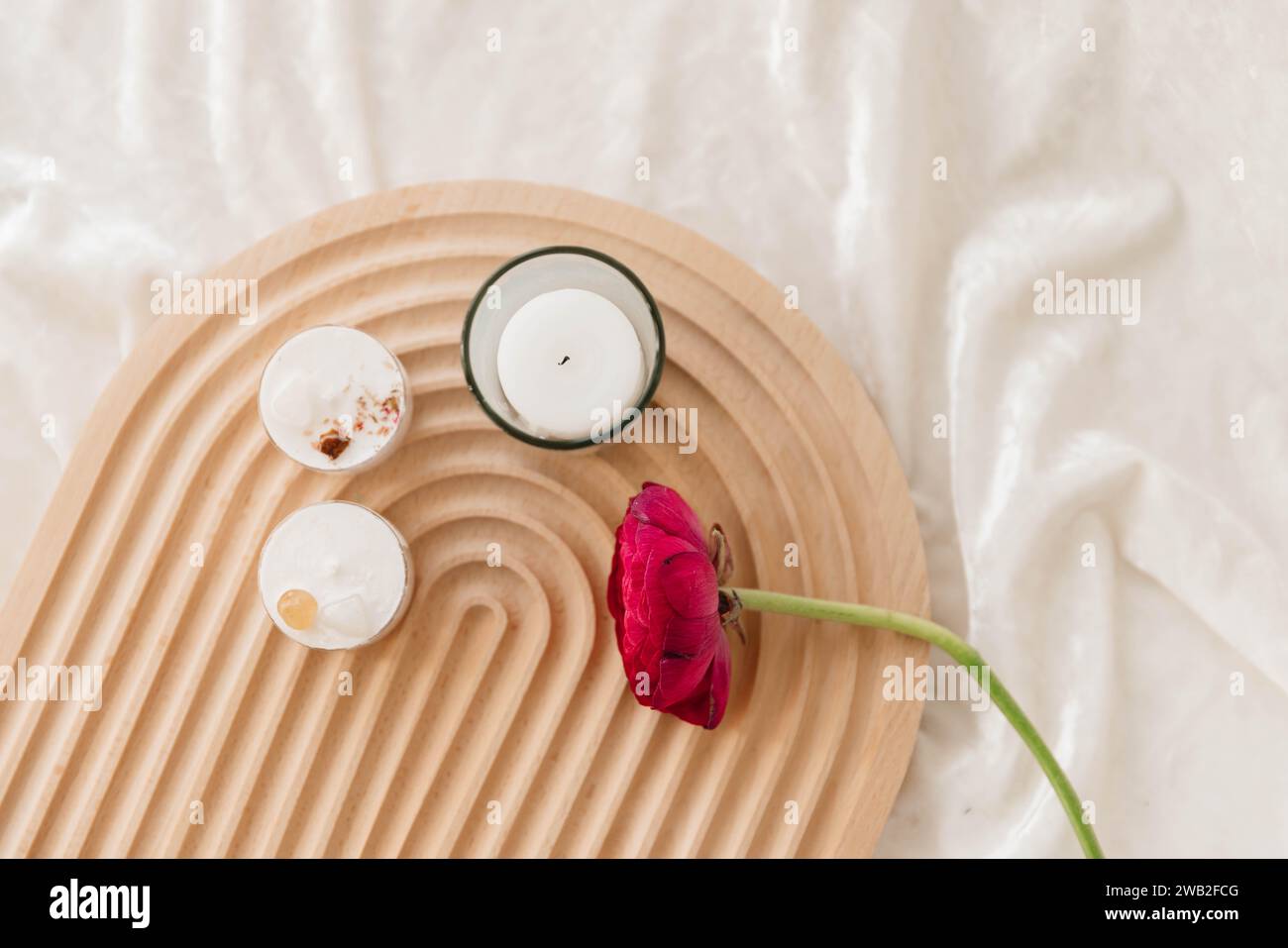 Benessere in stile nordico con candele e stelo Ranunculus Foto Stock