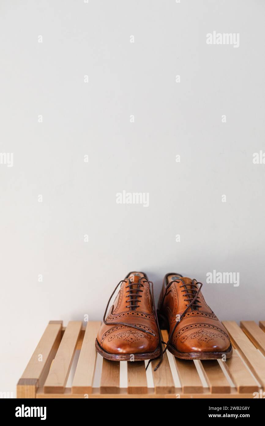 scarpe da uomo in pelle sedute su una panchina a casa Foto Stock