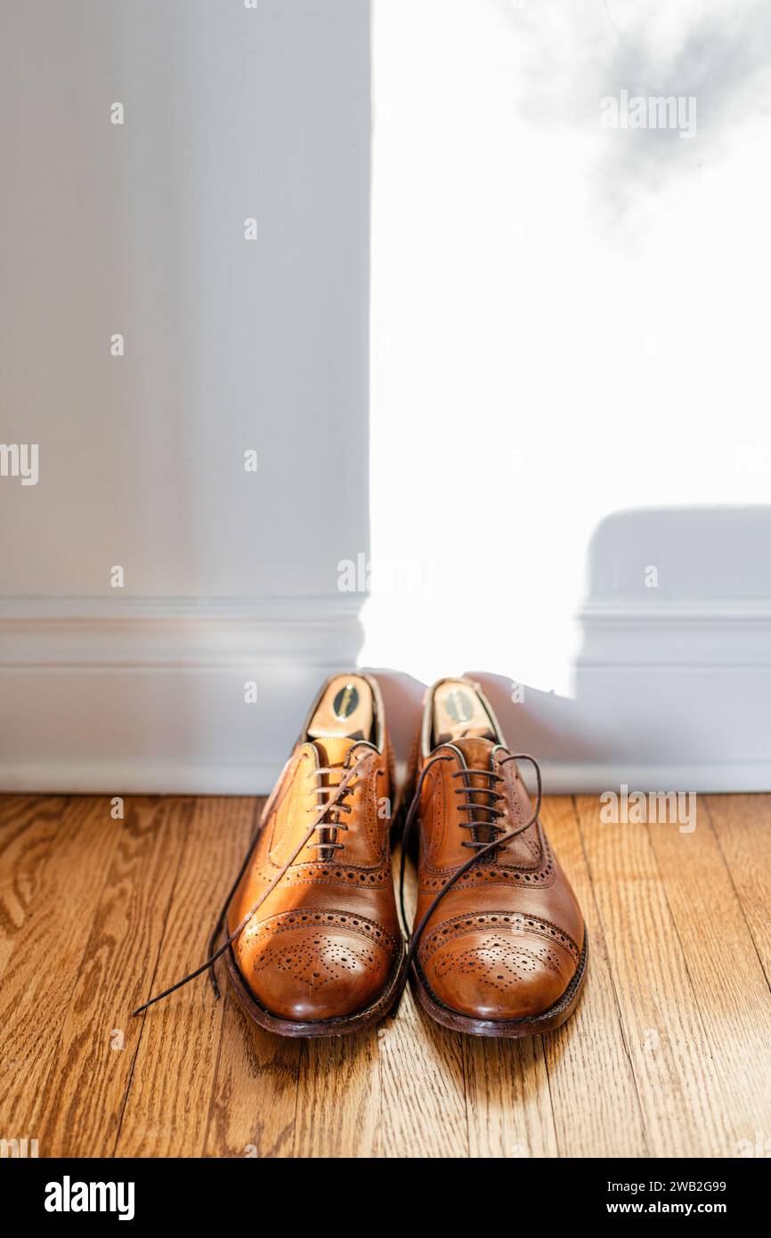 Scarpe da uomo in pelle marrone sul pavimento in legno duro Foto Stock