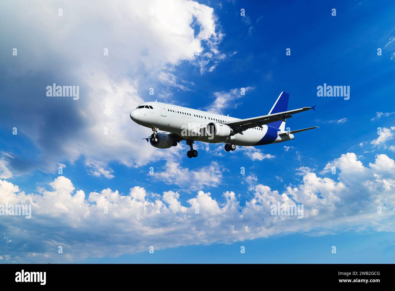Un aereo passeggeri sta volando in un bel cielo blu con nuvole bianche. Foto Stock