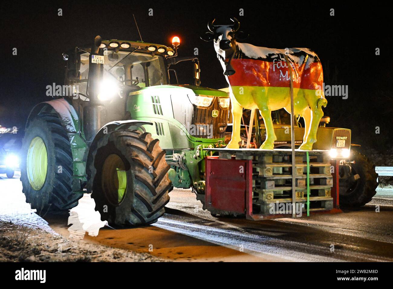 Rottenburg Kreis Tuebingen 08.01.2024 Bauernprotesta: Um 5 Uhr blockieren Landwirte mit Traktoren den Autobahnzubringer der B 28 an der Abzweigung zu L 361 nach Seebronn, die Zufahrten zur A 81 an der Anschlussstelle Rottenburg. Ein Traktor Hat eine Kuh aus Kunststoff dabei. *** Rottenburg distretto di Tuebingen 08 01 2024 contadini protestano alle 5 del mattino, agricoltori con trattori bloccano la strada di raccordo della B 28 all'incrocio con la L 361 per Seebronn, le strade di accesso alla A 81 all'incrocio di Rottenburg Un trattore ha una mucca in plastica con esso Ulmer Foto Stock