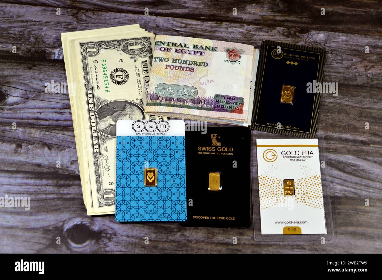 Cairo, Egitto, 2 gennaio 2024: Folded 200 EGP banconote in sterline egiziane e dollari americani USD, SAM, BTC, Swiss Gold, Gold era 24 Karate pure y Foto Stock