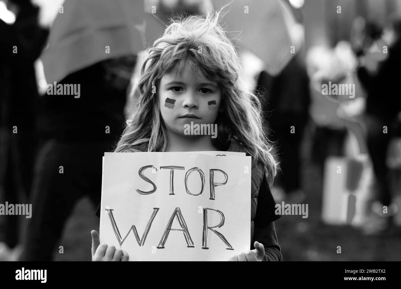 Ragazzo con un cartello con le parole Stop War in piedi all'aperto. Putin attacca il popolo ucraino. Protesta umana. Foto Stock