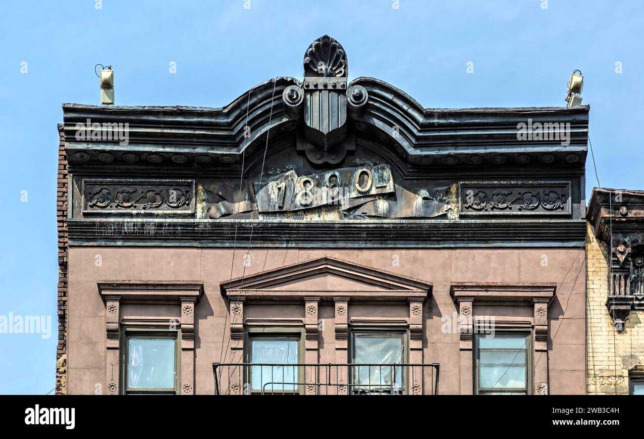 Un cornicione di metallo impresso si affaccia sulla 1968 Third Avenue, un edificio di appartamenti in mattoni e pietra marrone a cinque piani con negozi costruito nel 1890. Foto Stock