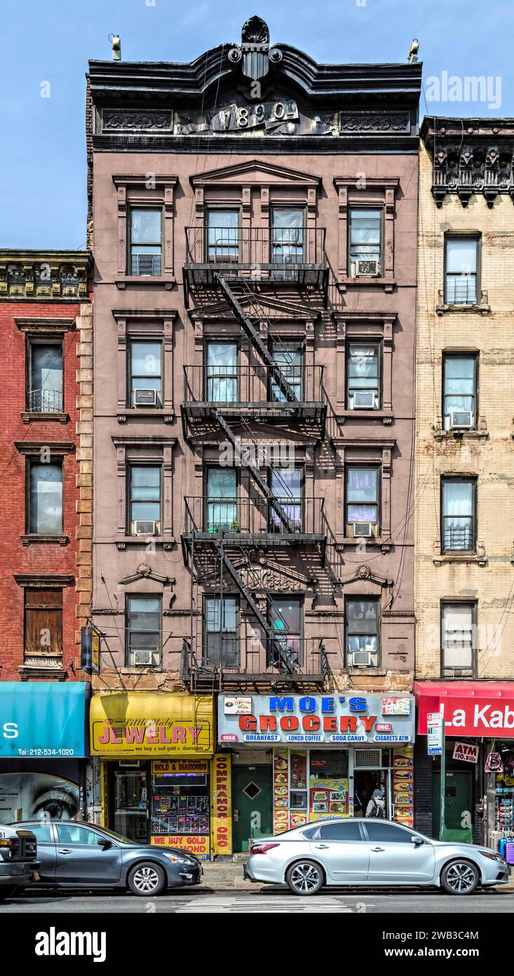 Un cornicione di metallo impresso si affaccia sulla 1968 Third Avenue, un edificio di appartamenti in mattoni e pietra marrone a cinque piani con negozi costruito nel 1890. Foto Stock