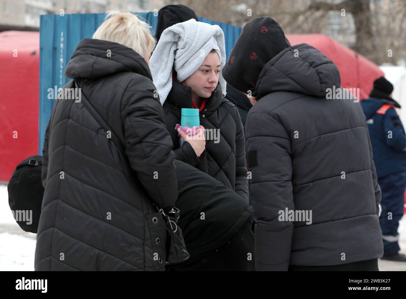 Non esclusiva: KIEV, UCRAINA - 6 GENNAIO 2024 - Una donna con un asciugamano sulla testa tiene un pallone sottovuoto dopo essersi tuffata nel fiume Obolonska Nabere Foto Stock