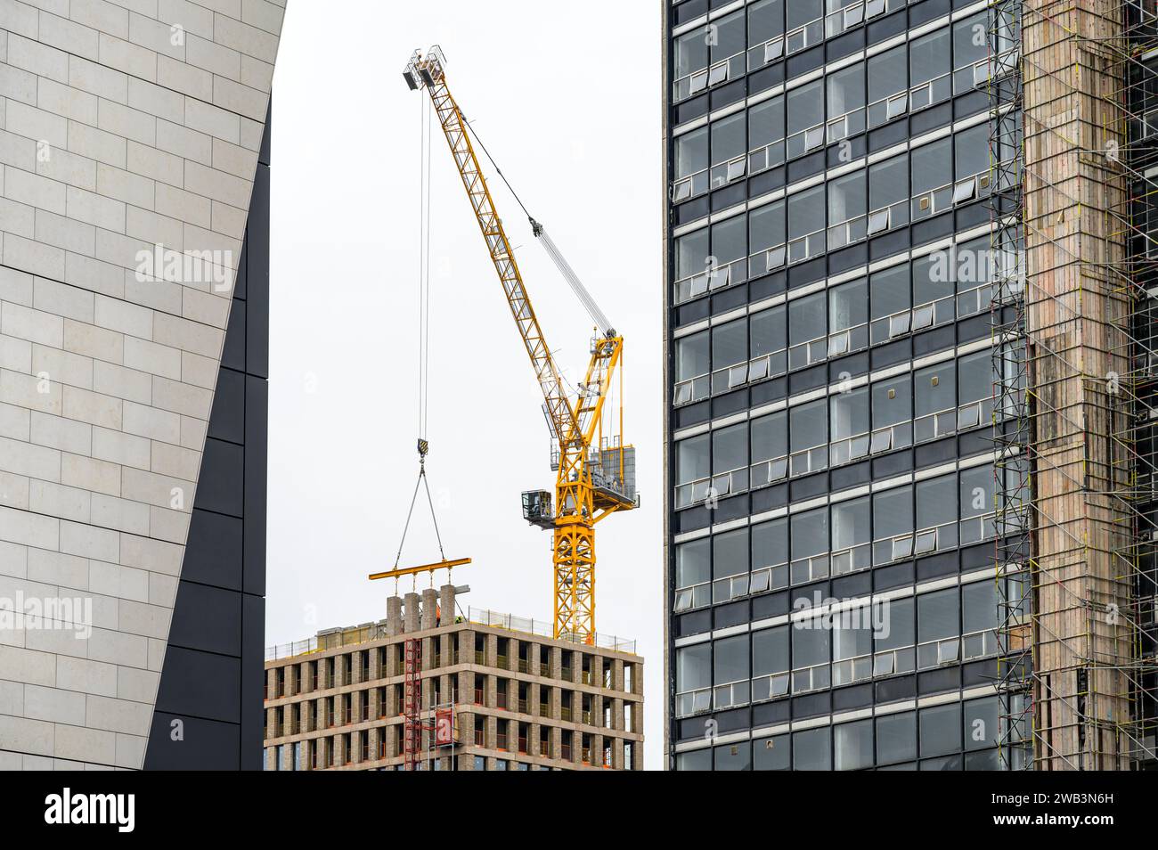 Trave di calcestruzzo sollevata in posizione da una gru a torre per costruzioni, John Street, Glasgow, Scozia, Regno Unito, Europa Foto Stock