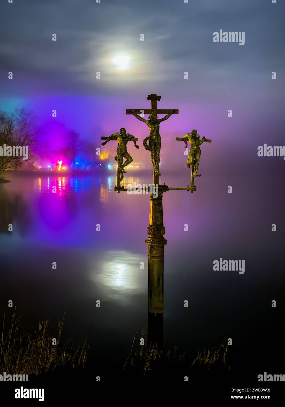 Mainau, Germania - 27 dicembre 2023: Storica statua della crocifissione e giardino di Natale, evento annuale con bellissime creazioni di luce e illuminazioni Foto Stock