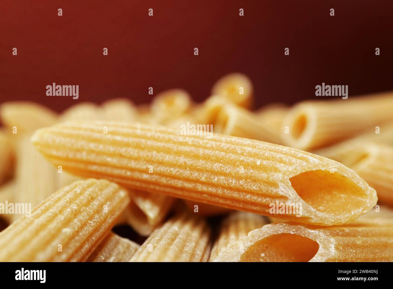Primo piano della superficie scanalata della pasta rigata di penne secche Foto Stock