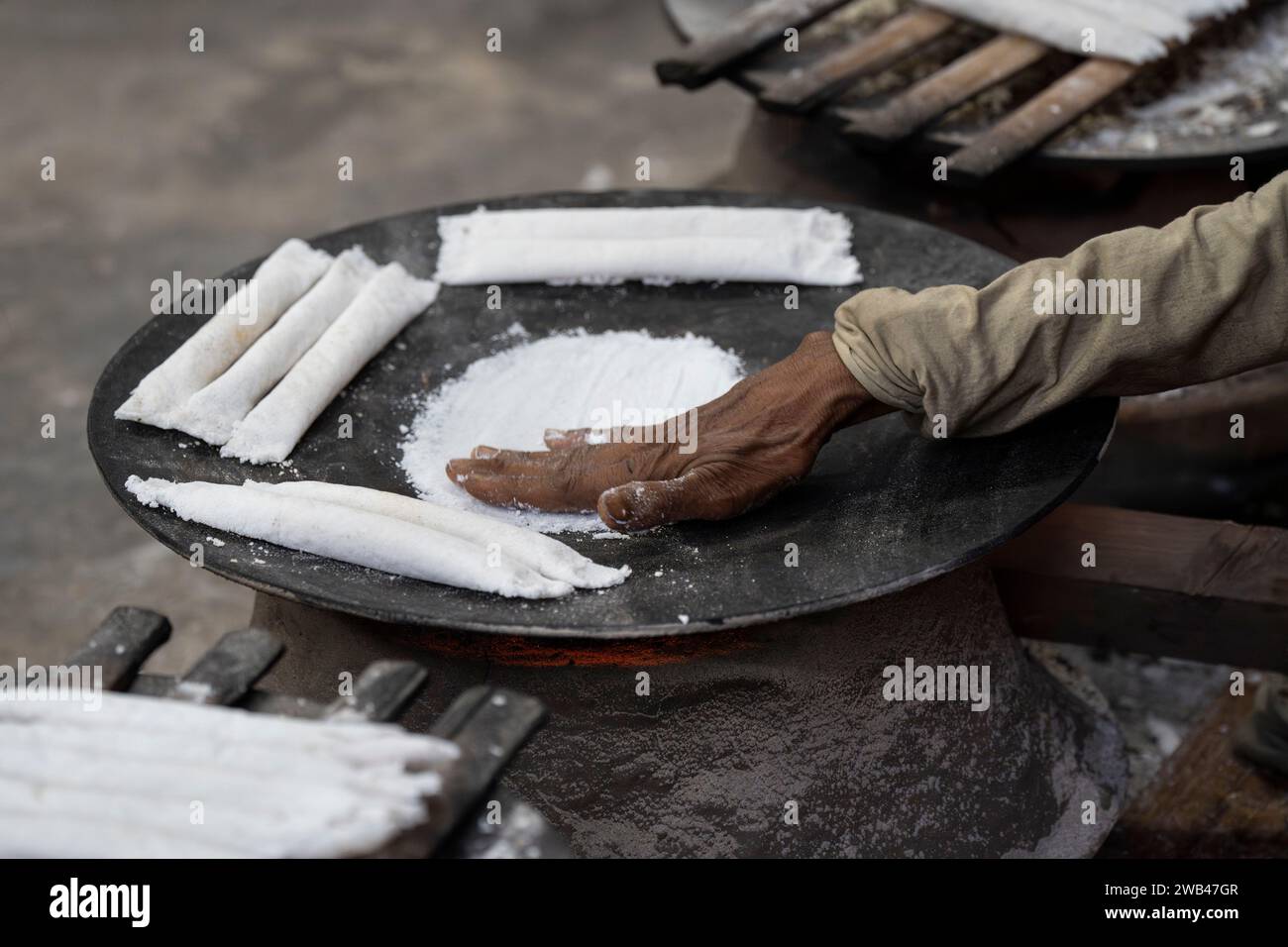 8 gennaio 2024: Le donne rendono il pitha tradizionale assamese (torta di riso) davanti a Magh Bihu, noto anche come Bhogali Bihu festival, l'8 gennaio 2024 a Guwahati, Assam, India. Magh Bihu, noto anche come Bhogali Bihu, è un festival del raccolto celebrato nello stato indiano dell'Assam. (Immagine di credito: © David Talukdar/ZUMA Press Wire) SOLO USO EDITORIALE! Non per USO commerciale! Foto Stock