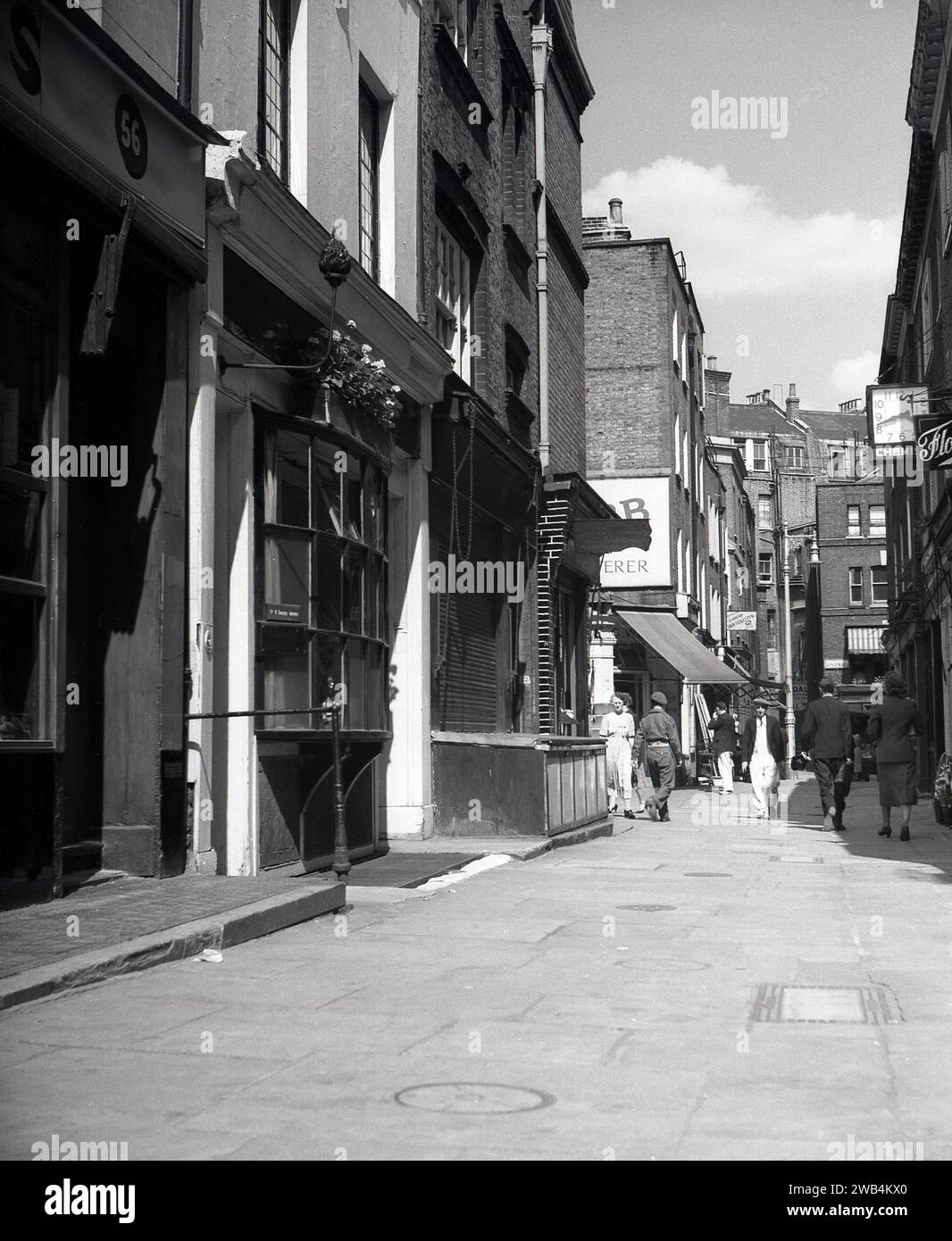 1950, storico vicolo lastricato a Shepherd Market, Mayfair, Londra, Inghilterra, Regno Unito. Un'affascinante piazza del XVIII secolo con negozi indipendenti, pub e ristoranti tra Piccadilly e Curzon Street nel West End di Londra, Shepherd Markert fu costruito tra il 1735 e il 1746 dal suo architetto e sviluppatore, Edward Shepherd, una figura di spicco del suo tempo. Foto Stock
