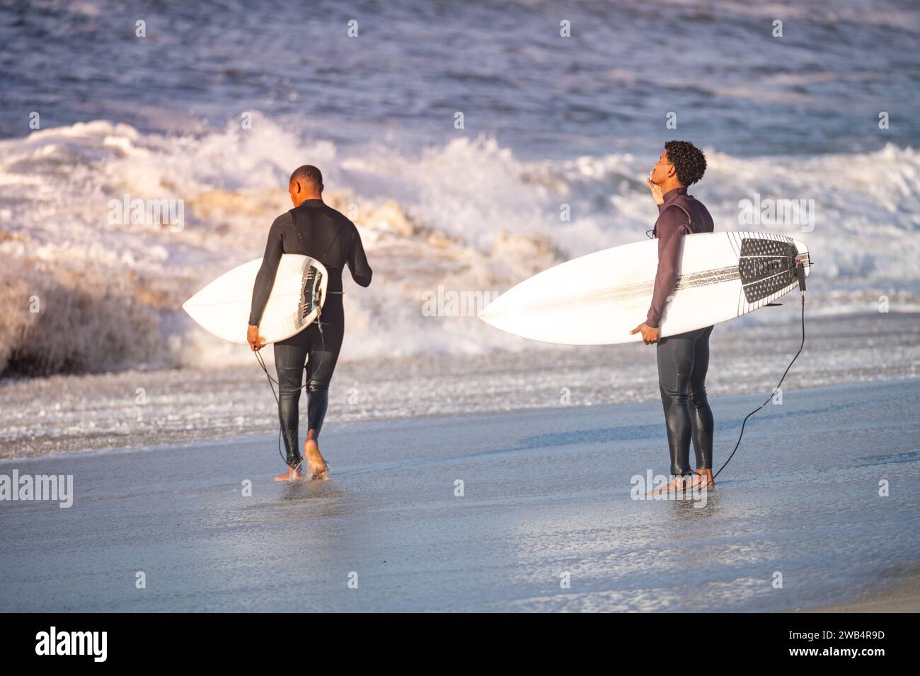 Surfisti che si preparano ad entrare nell'oceano. Foto Stock
