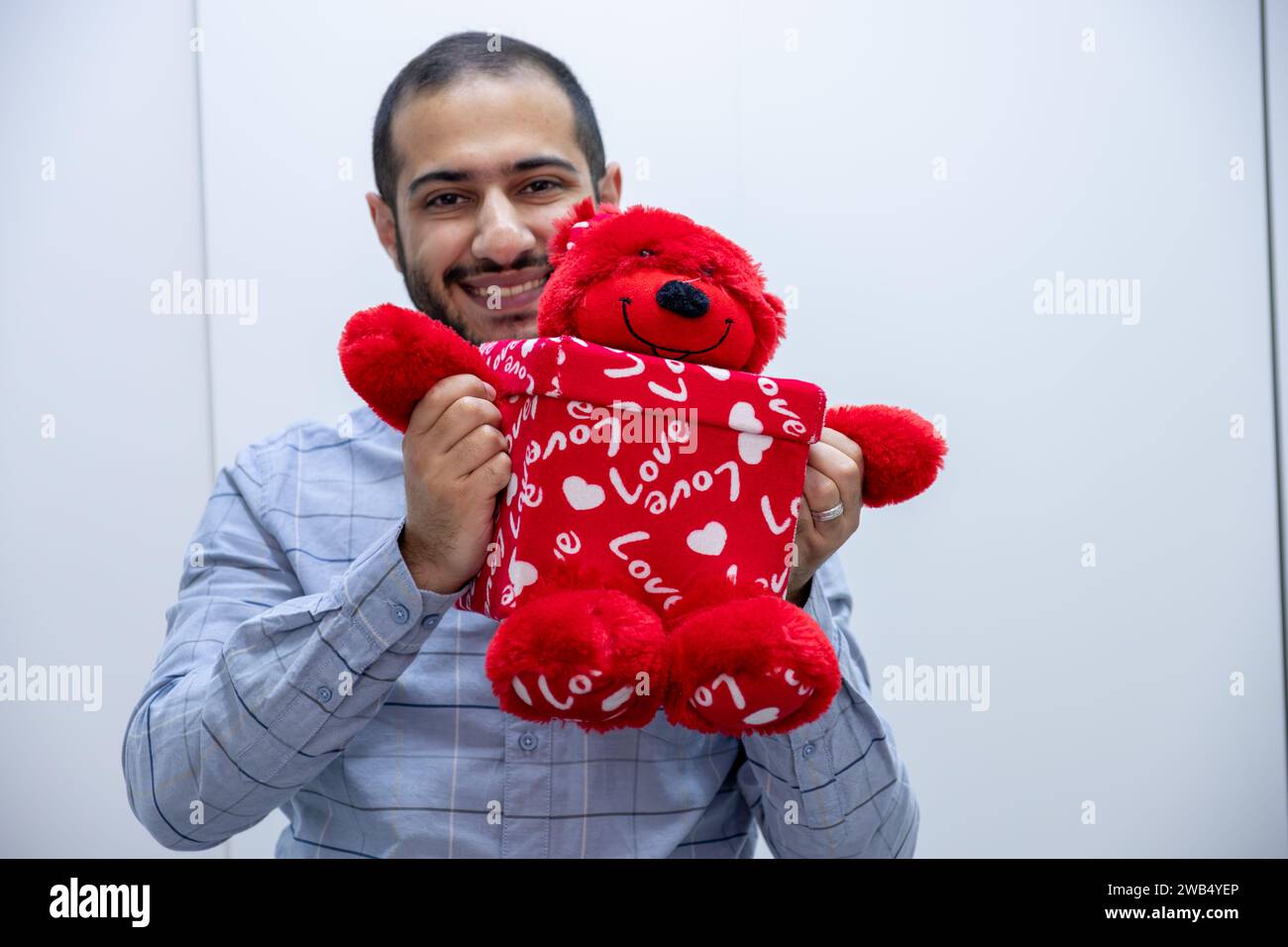uomo che regge una confezione regalo con cuori rossi come regalo Foto Stock