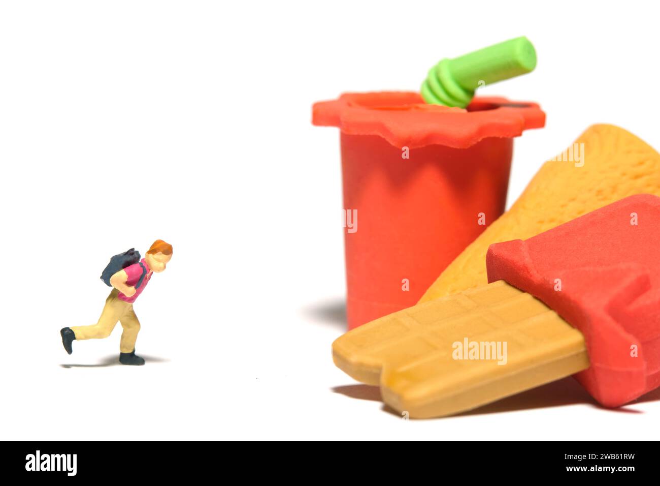 Fotografia di figure giocattolo per persone in miniatura. Concetto di cibo sano mangiare e pausa pranzo. Un ragazzo che corre verso uno spuntino al cioccolato e una bevanda analcolica. Isolato su wh Foto Stock