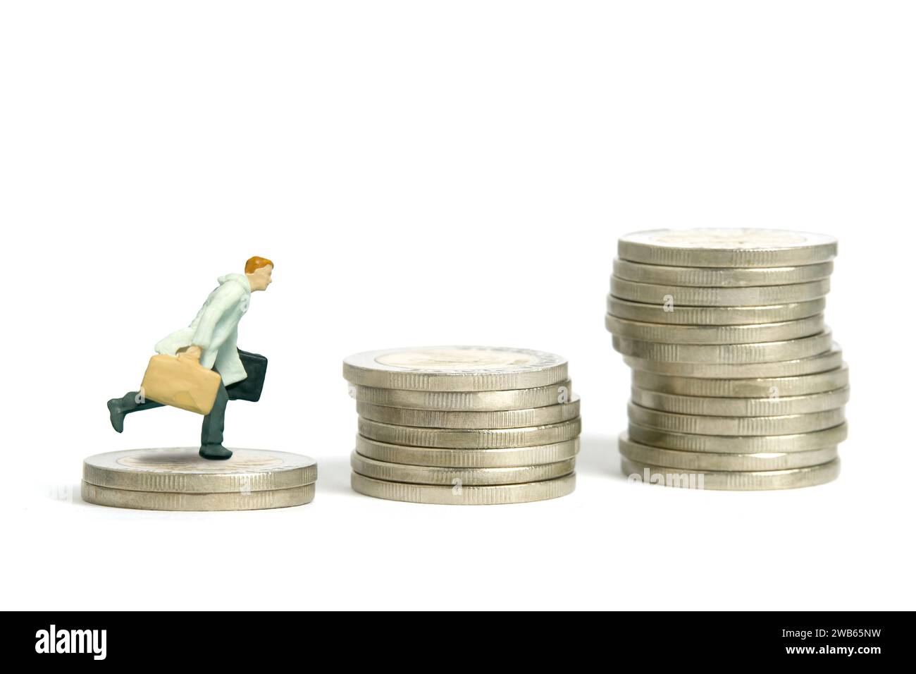 Fotografia di figure giocattolo in miniatura. Un uomo d'affari che indossa un cappotto che salta sopra le scale a gettoni. Isolato su sfondo bianco. Foto immagine Foto Stock