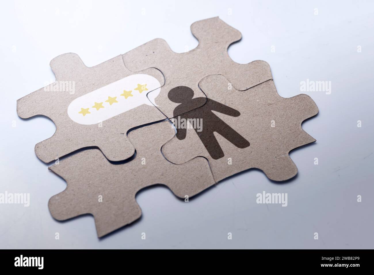 Vista ravvicinata di un puzzle con la figura umana e la valutazione a cinque stelle. Concetto di business e servizio Foto Stock