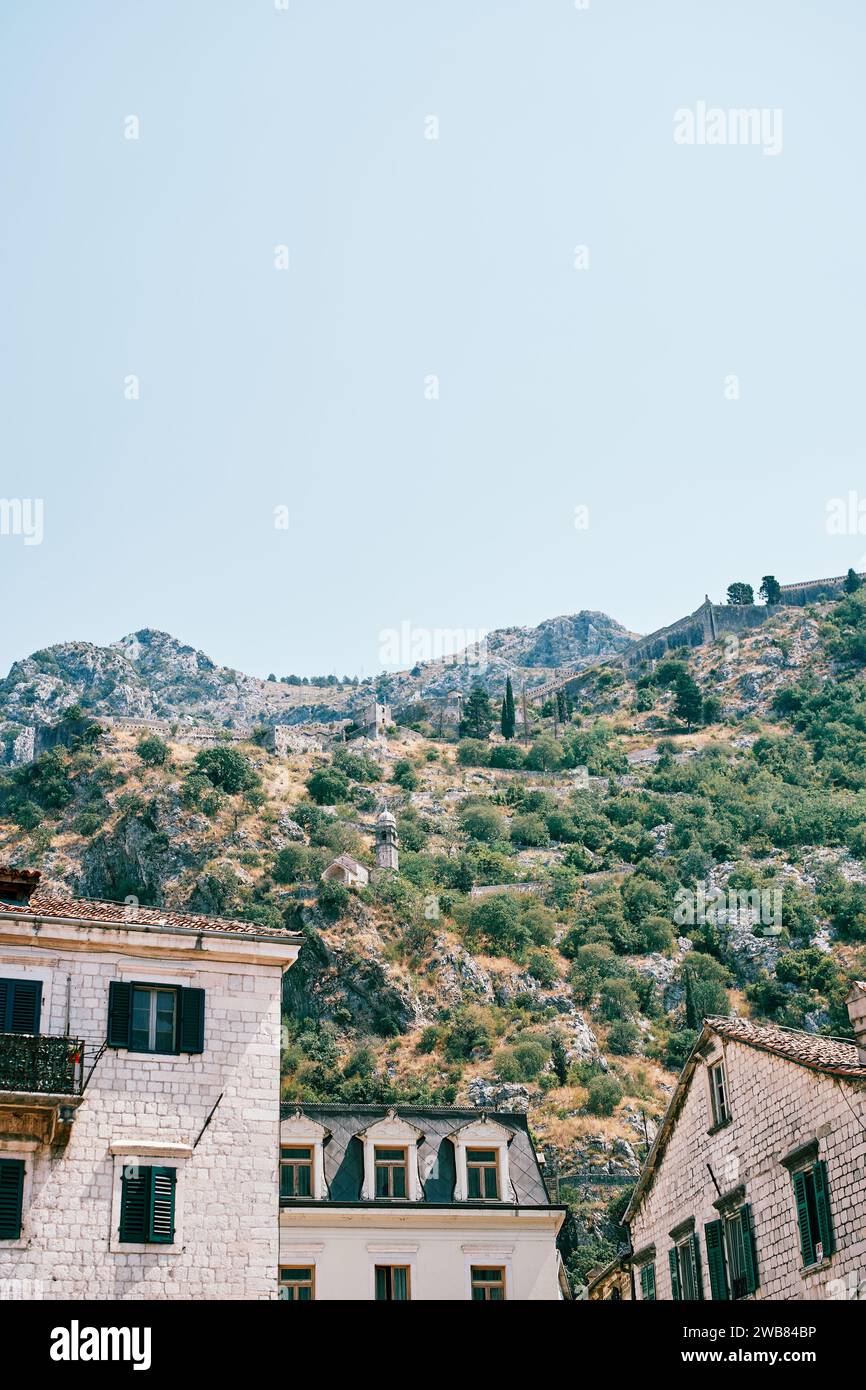 Vecchi edifici in pietra e la Cappella della Madonna della salvezza in montagna. Kotor, Montenegro Foto Stock