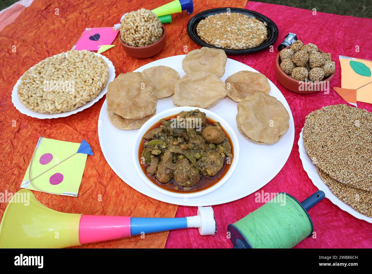 Cibo speciale Makar sankranti, cibo del festival Uttarayan Undhiyu e poori con Til gud patti, chikki, laddoo di riso ripieno mangiato durante i festi dell'aquilone Foto Stock