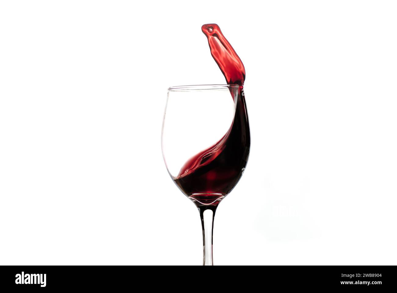 Un bicchiere di vino rosso cristallino su uno sfondo bianco incontaminato Foto Stock