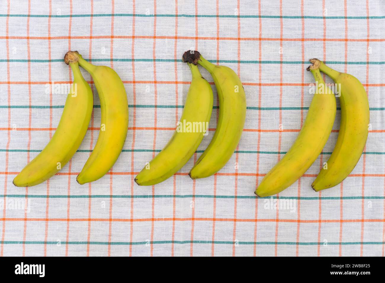 Banane gialle mature su tovaglia bianca Foto Stock
