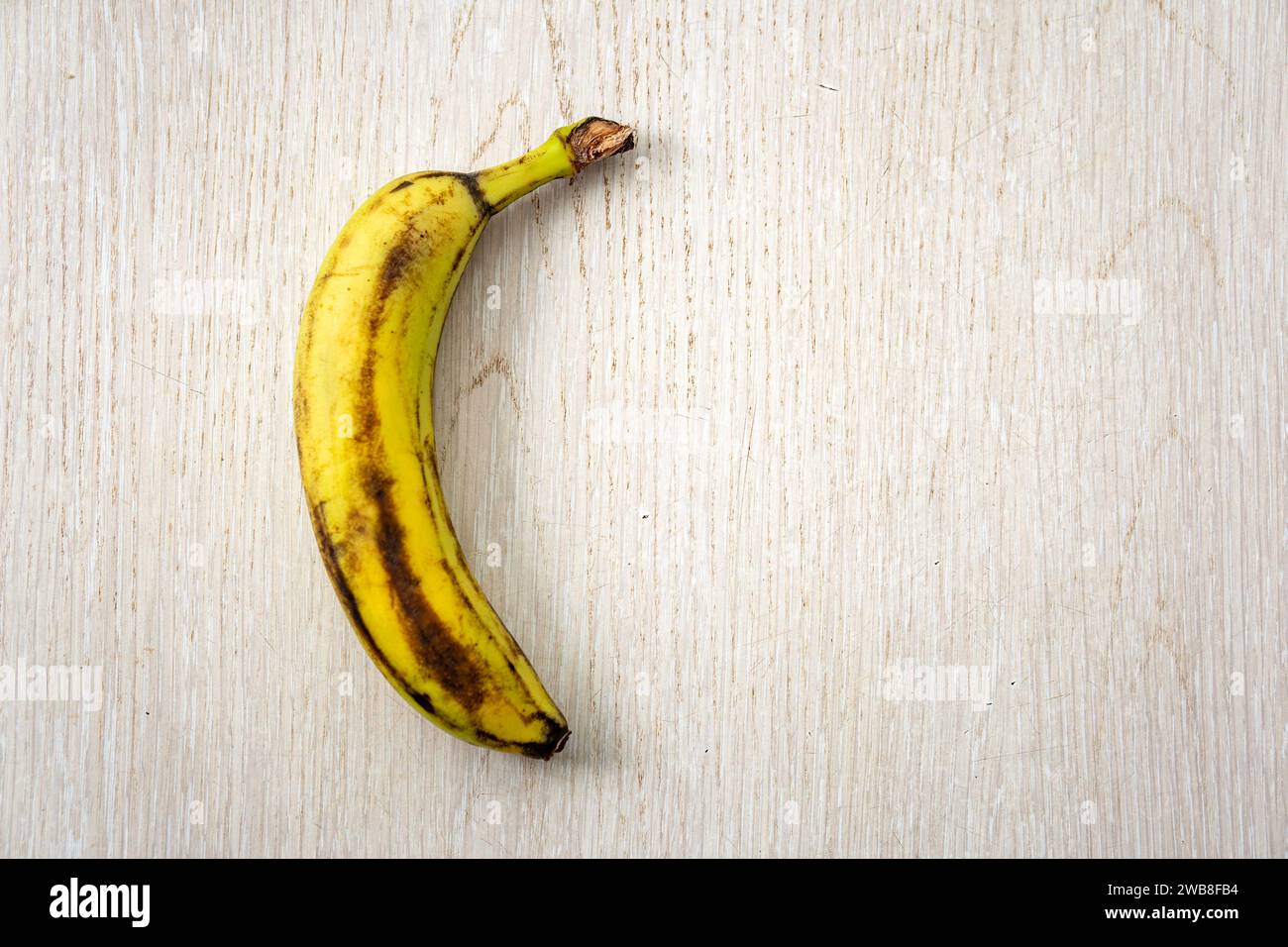 Sopra una banana matura isolata su uno sfondo di legno. Foto Stock