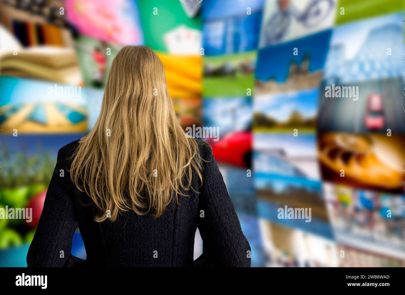 donna bionda davanti a un muro con molte foto Foto Stock
