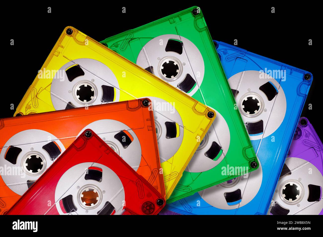 Cassette audio compatte in plastica trasparente colorata allineate a forma di ventola su sfondo nero. Colori vivaci dell'arcobaleno LGBT. L'immagine è S Foto Stock