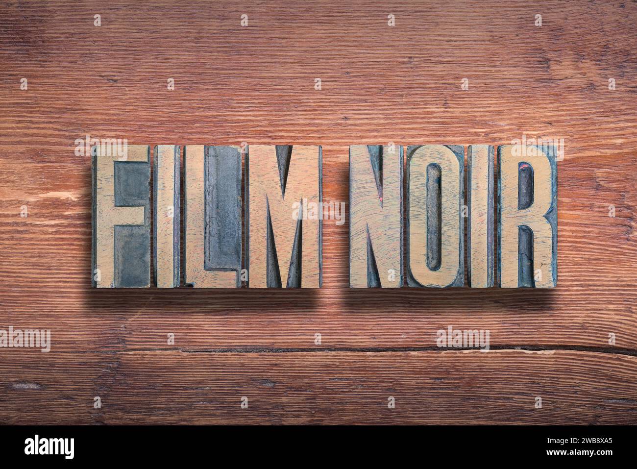 Film noir, una frase francese comunemente usata che significa "film nero", un genere di film a tema scuro, combinati su una superficie in legno verniciato d'epoca Foto Stock