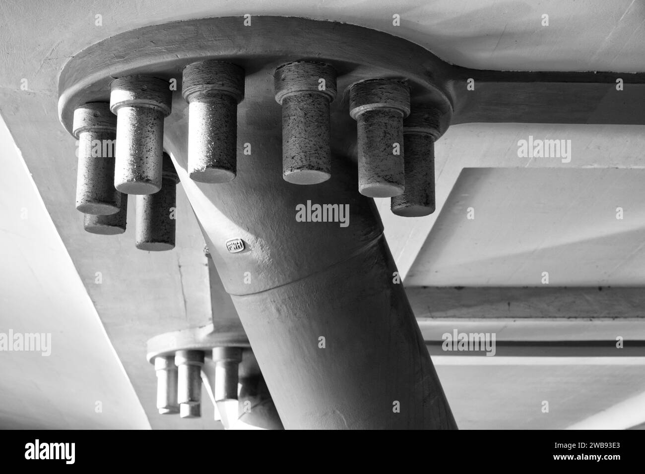 Un primo piano di viti metalliche fissate sul lato inferiore di una struttura a ponte Foto Stock