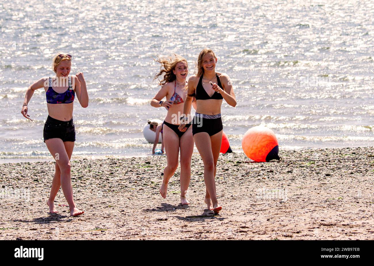 Durante il caldo clima estivo, le giovani donne si divertono lungo la spiaggia di Broughty Ferry a Dundee, in Scozia, nel Regno Unito Foto Stock