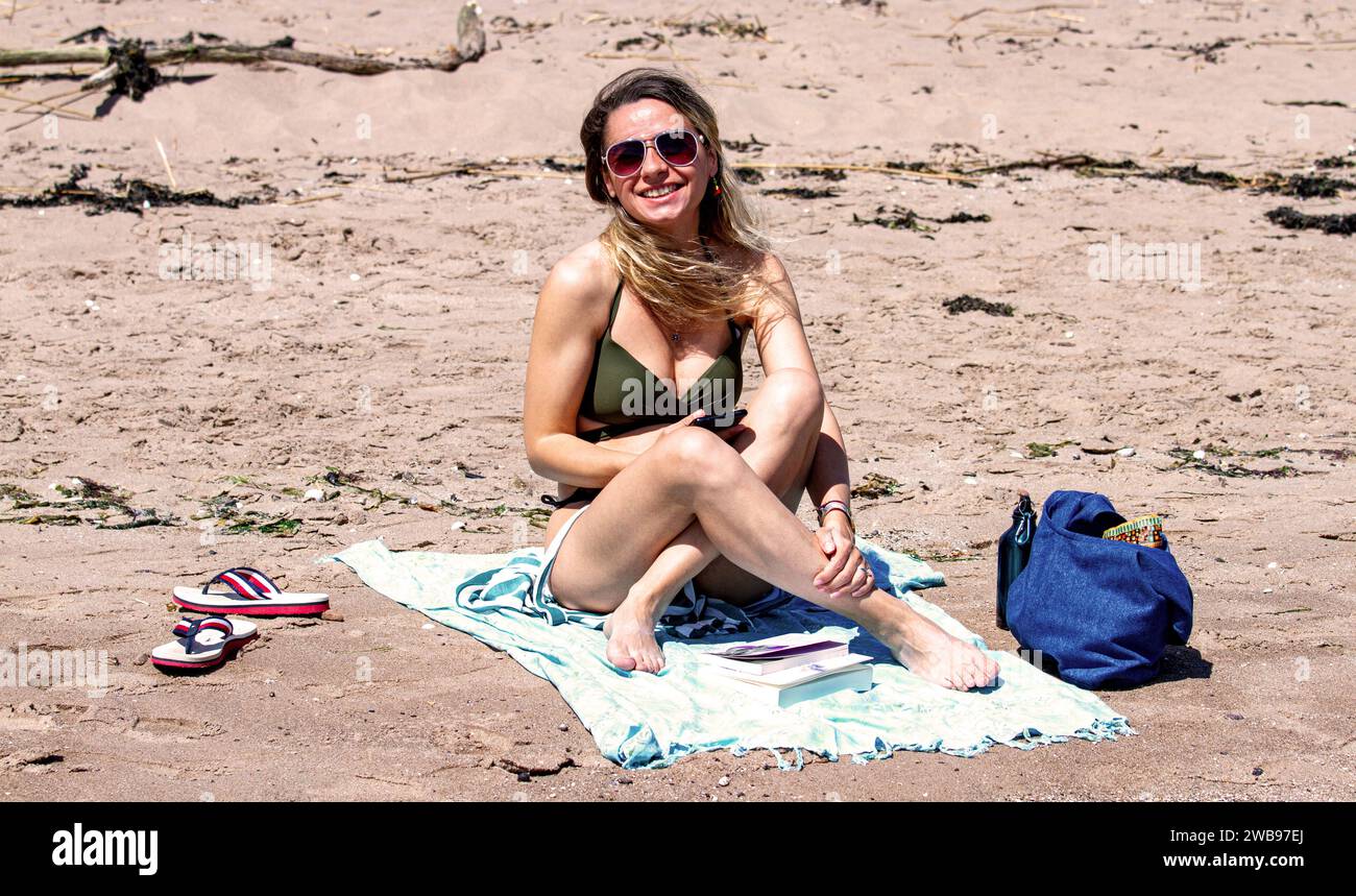 Con un glorioso clima caldo a Dundee, le donne locali prendono il sole lungo la spiaggia di Broughty Ferry durante l'onda di caldo estiva in Scozia, Regno Unito Foto Stock