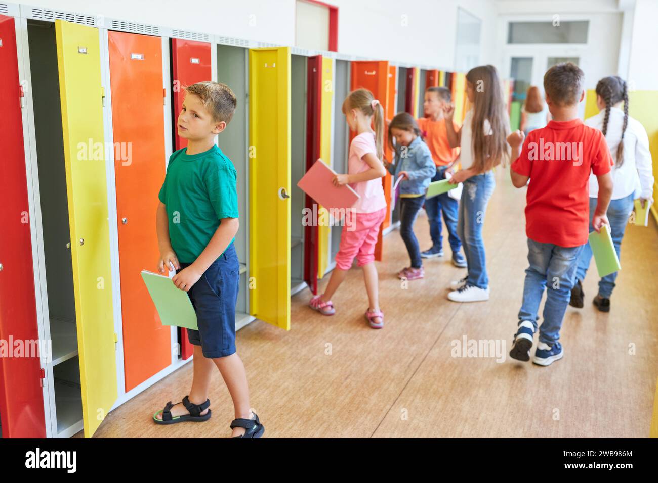Gruppo di bambini delle scuole elementari nei loro armadietti nel corridoio durante la pausa Foto Stock