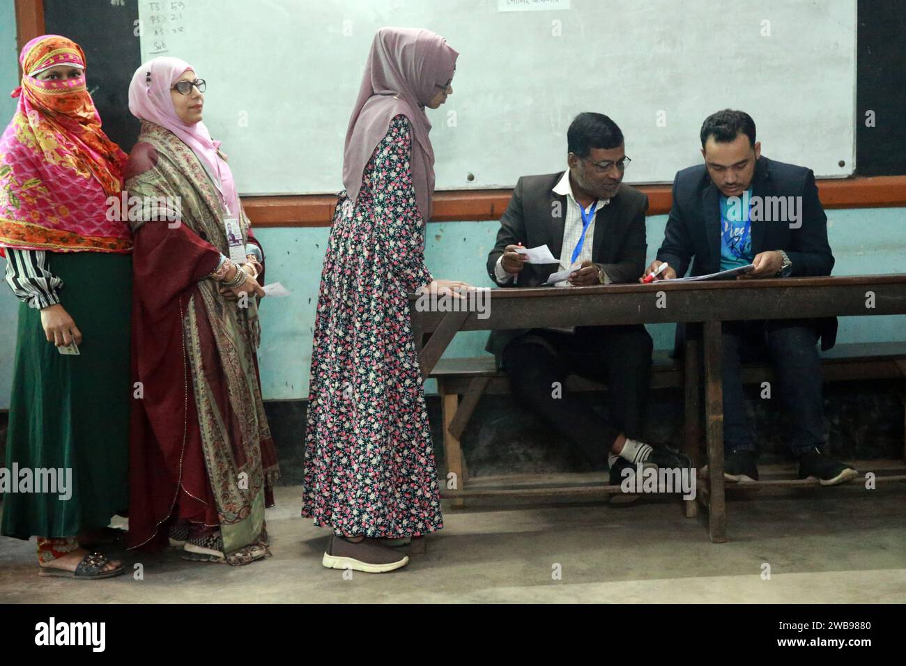 Gli elettori in coda per votare in un centro elettorale della Hammadia High School, Dacca, Bangladesh, 7 gennaio 2024. Foto Stock