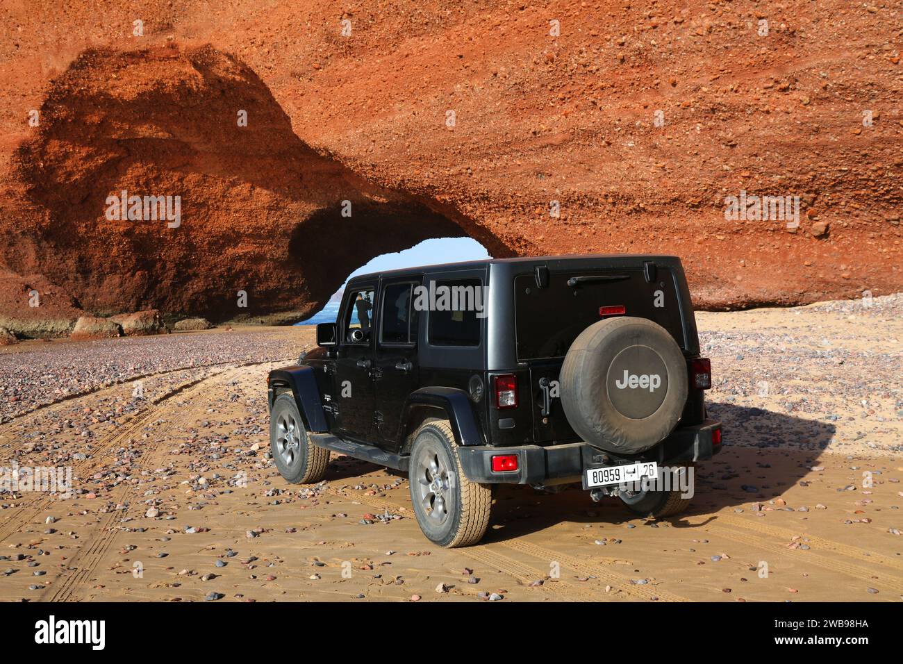 LEGZIRA, MAROCCO - 14 FEBBRAIO 2022: Black Jeep Wrangler parcheggiata sulla spiaggia di Legzira vicino a Sidi Ifni in Marocco. Foto Stock