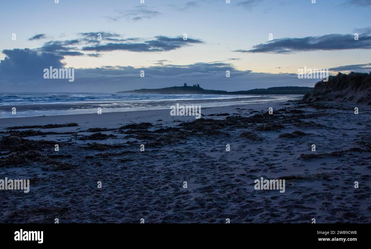 Castello di Dunstanburgh all'alba Foto Stock