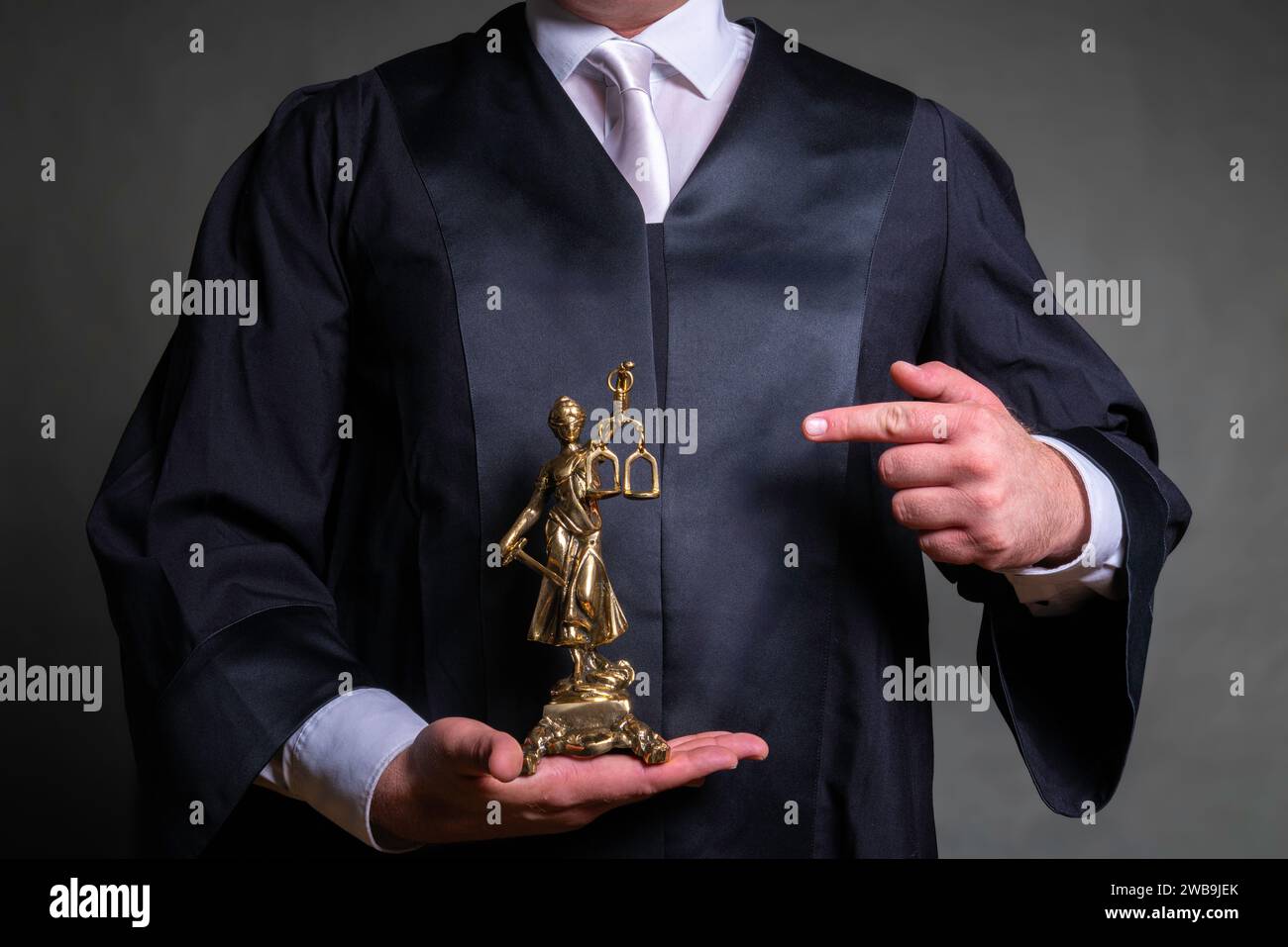 Avvocato tedesco con una classica veste nera e cravatta bianca che regge una statua di Lady Justice Foto Stock