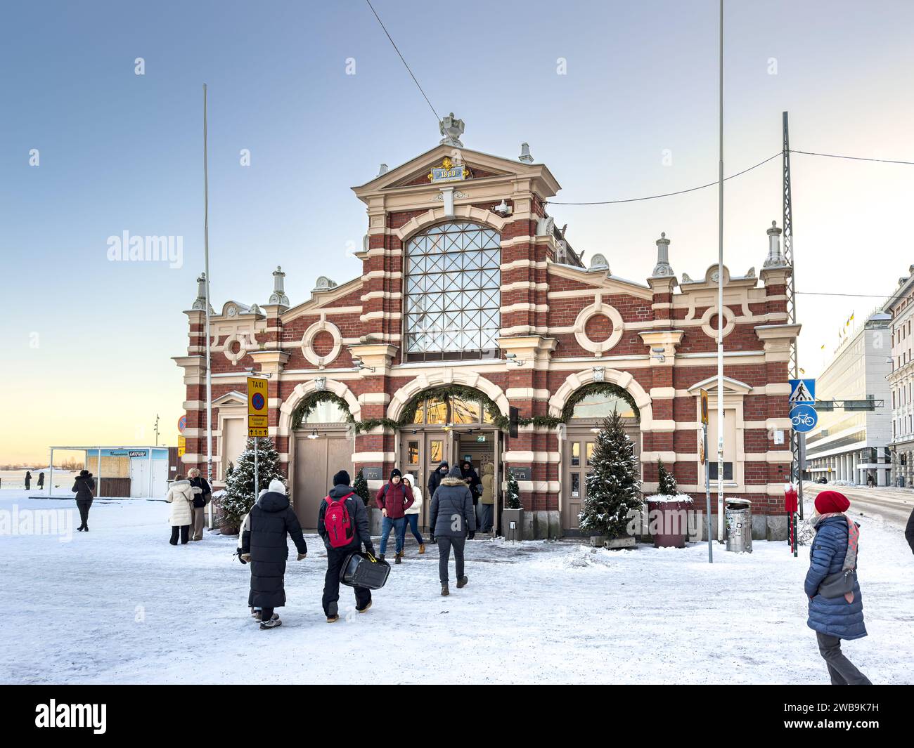 I clienti che entrano nella vecchia sala del mercato di Helsinki, Finlandia, in inverno Foto Stock