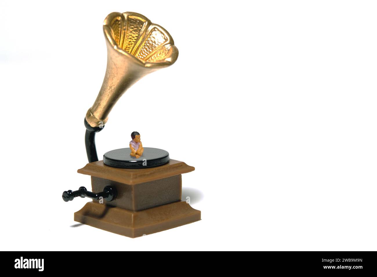 Fotografia di figure giocattolo in miniatura. Musica per lo sviluppo del cervello. Un seggiolino per bambini sopra il vinile in gramafono antico d'epoca. Isolato su whi Foto Stock