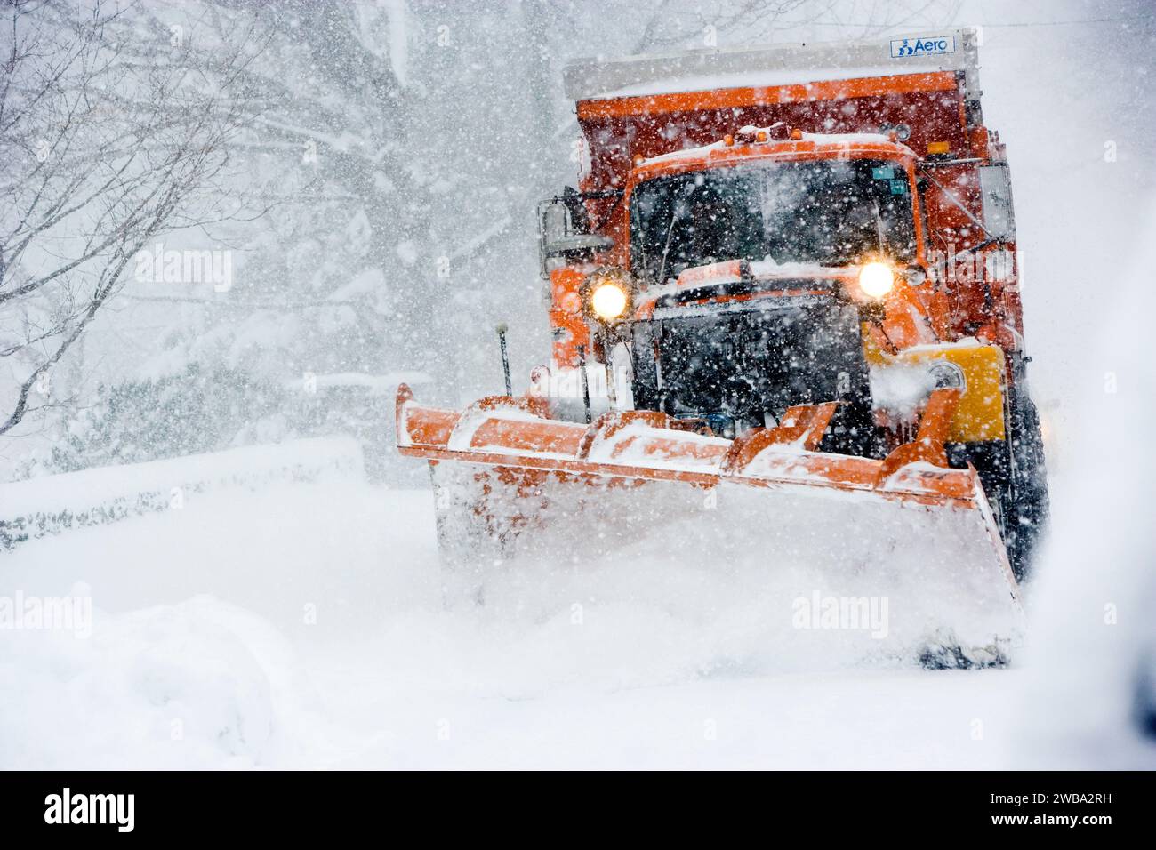 Un pesante spazzaneve sgombra una strada principale del Vermont facendo una tormenta invernale Foto Stock
