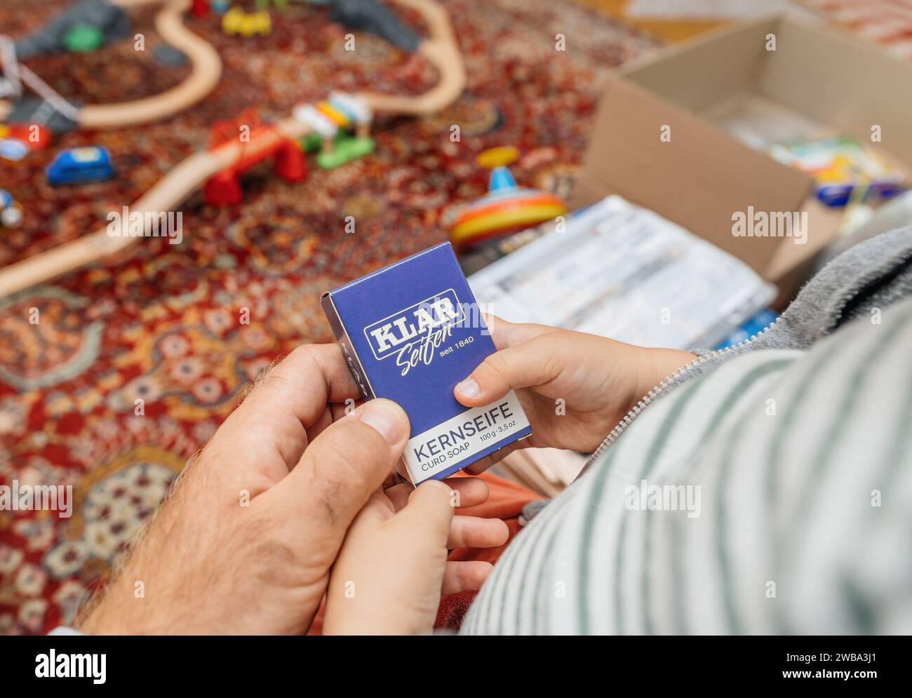 Parigi, Francia - 1 settembre 2023: Un bambino e un padre che esaminano un pacchetto di sapone tedesco Klar Seifen, del peso di 100 grammi, che ne dimostra la qualità e la semplicità Foto Stock