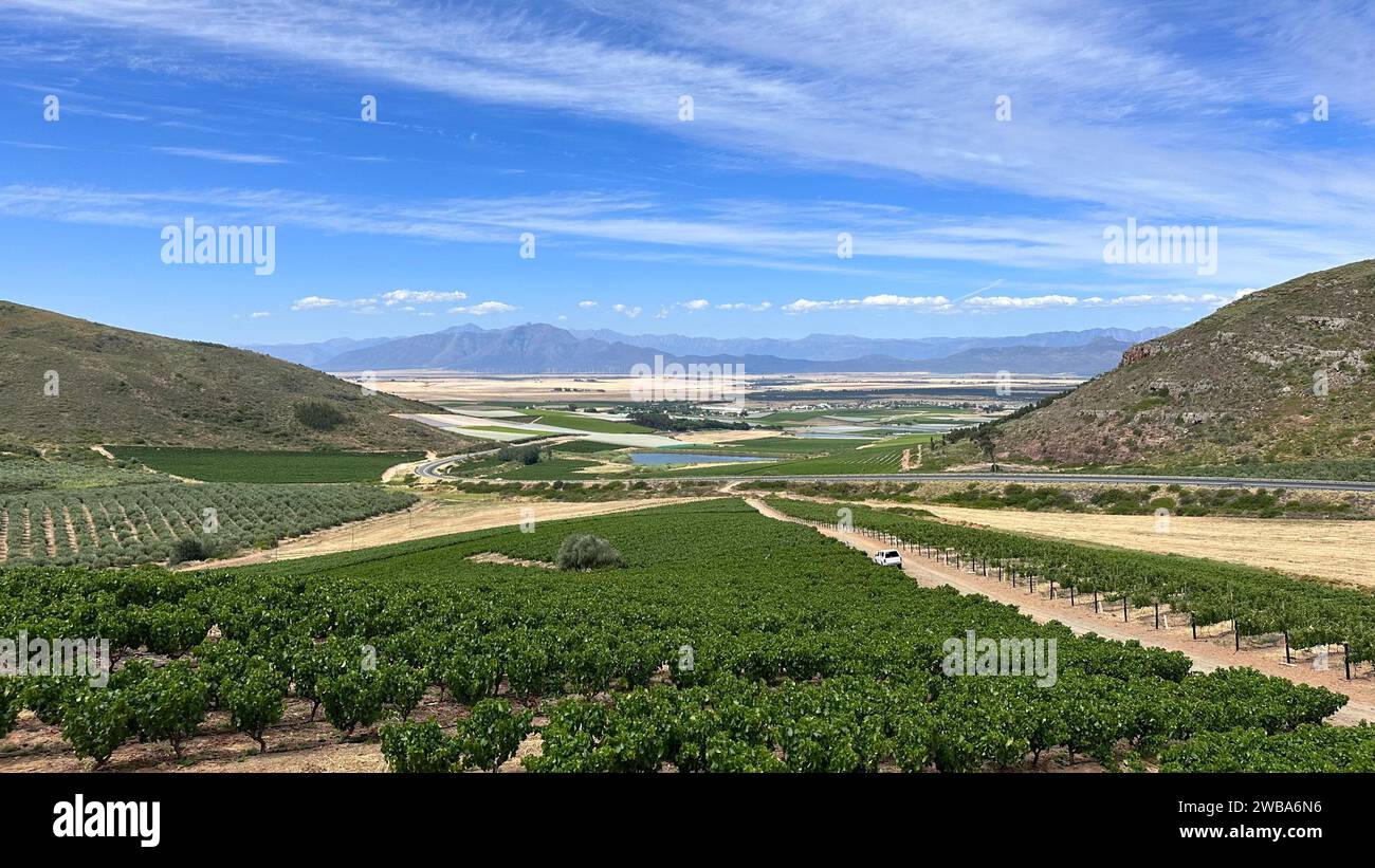 Una vista panoramica di una lussureggiante valle verde, circondata da colline ondulate, e caratterizzata da un tranquillo fiume che la attraversa Foto Stock