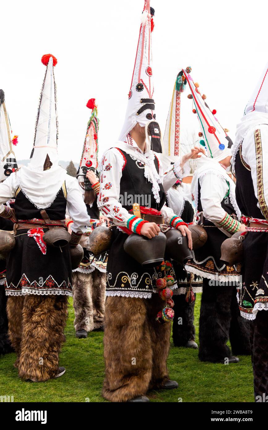 Ballerini Kukeri dalla Bulgaria centrale con costumi intricati, campane e maschere al festival invernale Simitlia a Simitli, Bulgaria, Europa orientale, UE Foto Stock
