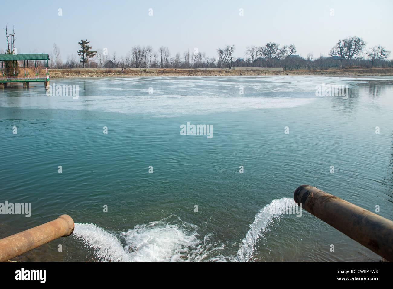 Srinagar, India. 9 gennaio 2024. Una vista del lago d'acqua parzialmente ghiacciato in una fredda giornata invernale nel villaggio periferico di Srinagar. Il Kashmir si trova attualmente nel bel mezzo del rigido periodo invernale di 40 giorni, conosciuto localmente come "Chilla-i-Kalan". Durante questo periodo, un'onda di freddo estremo avvolge la regione himalayana, causando un calo delle temperature fino a -20 gradi. Ciò comporta il congelamento dei corpi idrici, tra cui il rinomato lago dal, e delle linee di approvvigionamento idrico in varie parti della valle. (Foto di Faisal Bashir/SOPA Images/Sipa USA) credito: SIPA USA/Alamy Live News Foto Stock