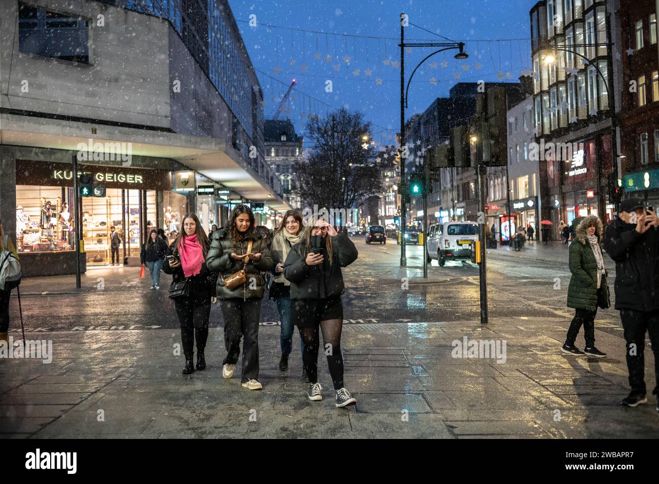 Gli amanti dello shopping affrontano il freddo inverno durante le nevi fredde e le docce a pioggia su Oxford Street, la High Street più trafficata di Londra, Inghilterra, Regno Unito Foto Stock