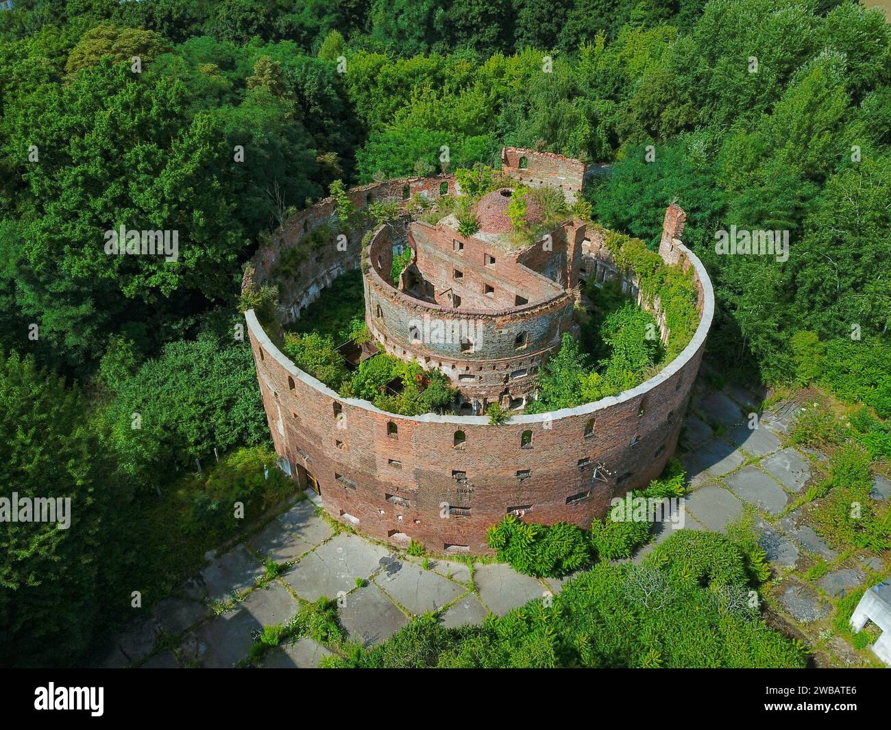 vecchio edificio militare abbandonato, fotografato da un drone mentre la natura lo sta lentamente riprendendo Foto Stock