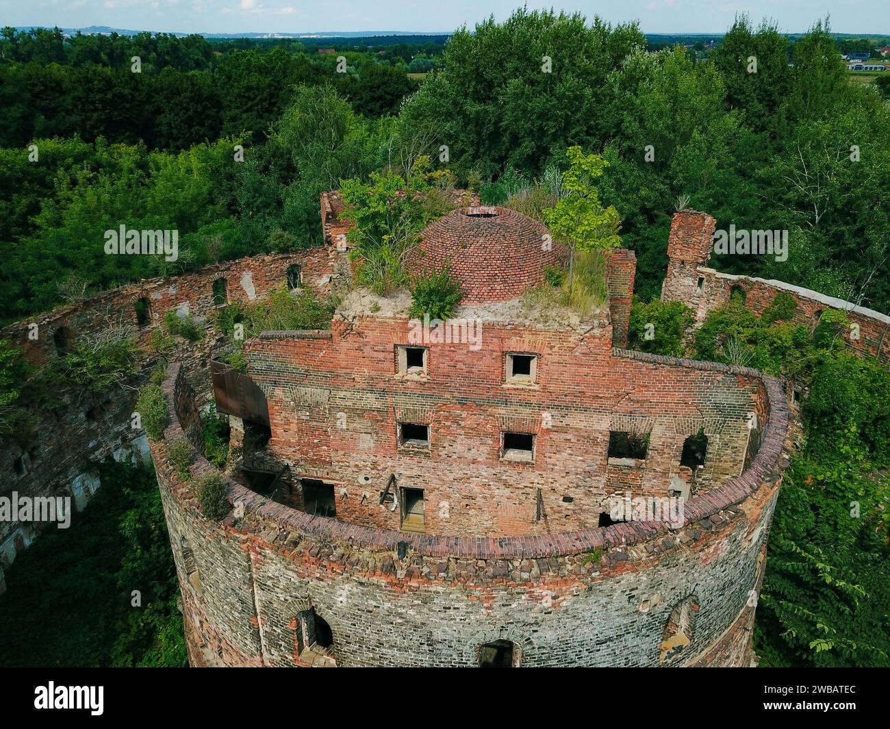 Un vecchio edificio militare abbandonato, fotografato da un drone mentre la natura lo sta lentamente riprendendo Foto Stock