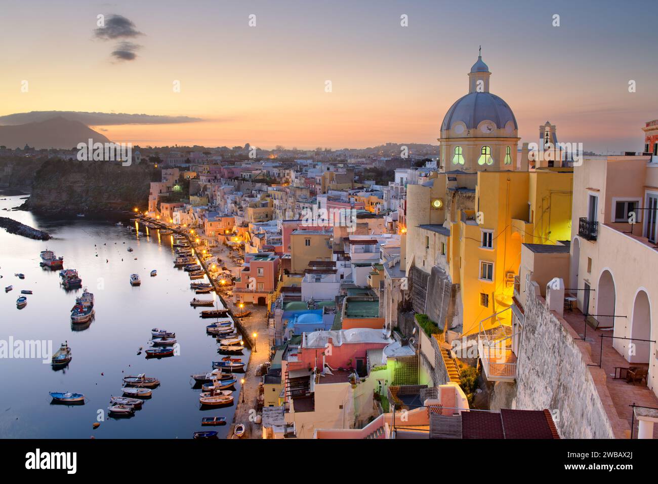 Procida, Italia skyline della città vecchia nel Mar Mediterraneo durante il tramonto. Foto Stock